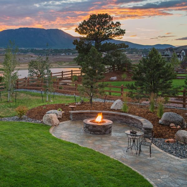 Custom fire area landscaping in Western Sydney with built-in stone fire pit and curved seating by West Sydney Landscapes